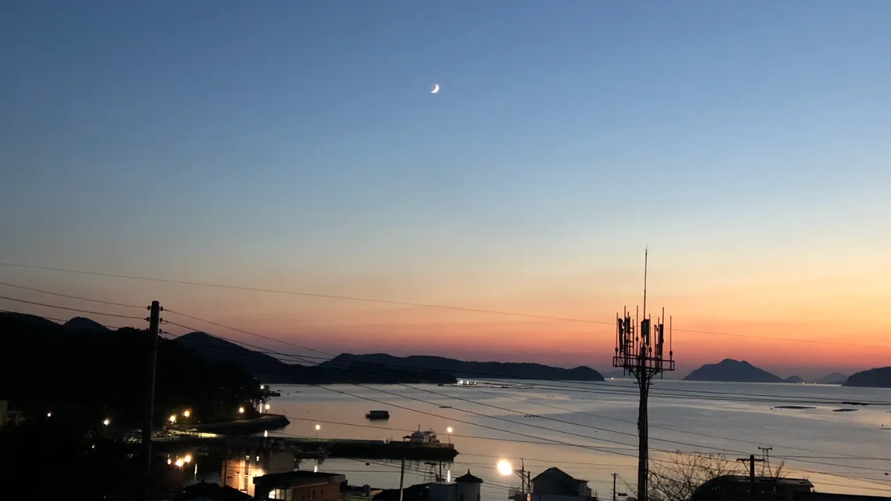 초승달이 뜬 저녁 하늘과 바다, 항구의 불빛